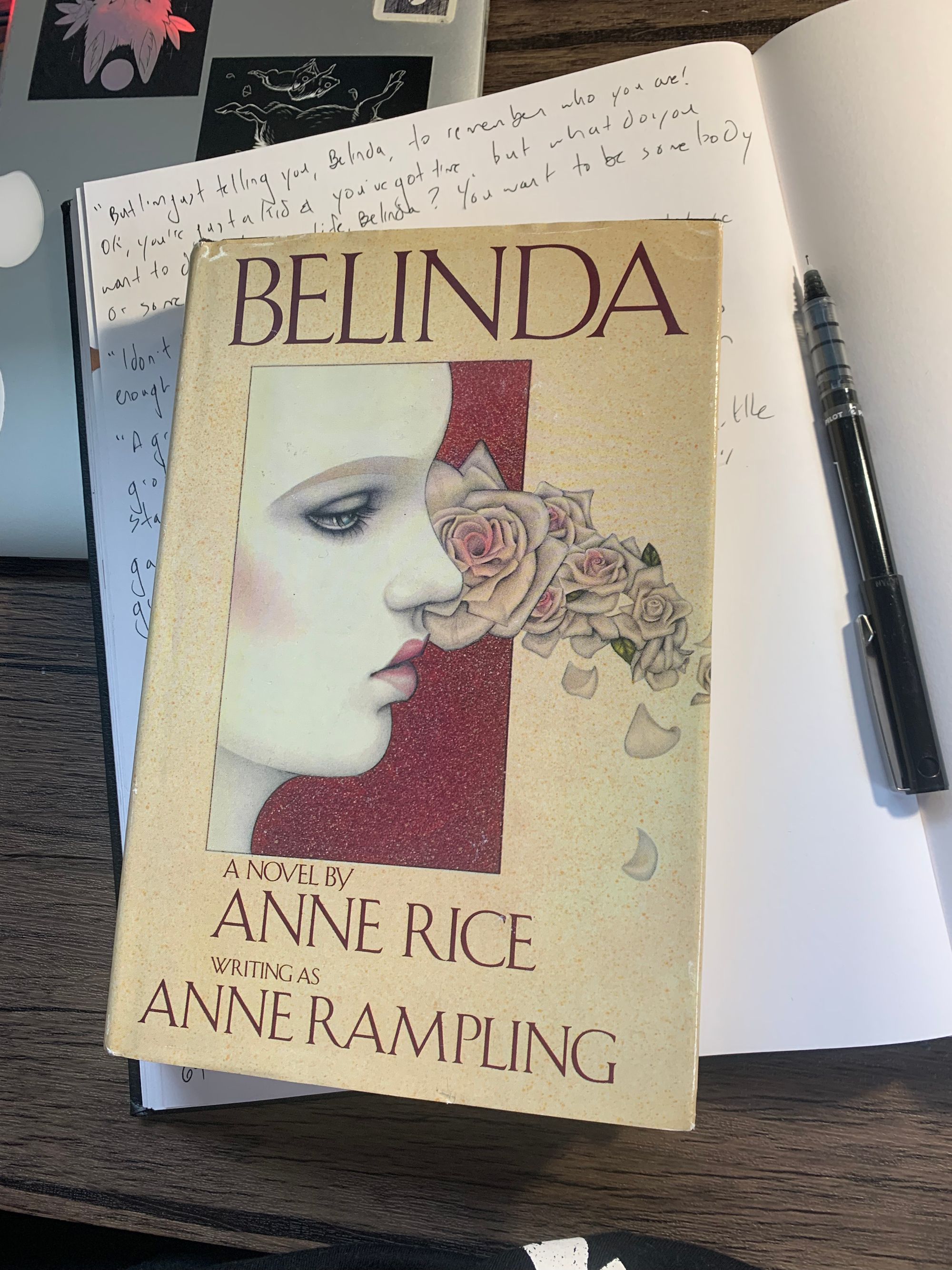 hardcover copy of Belinda by Anne Rice resting on white online notebook, black pen