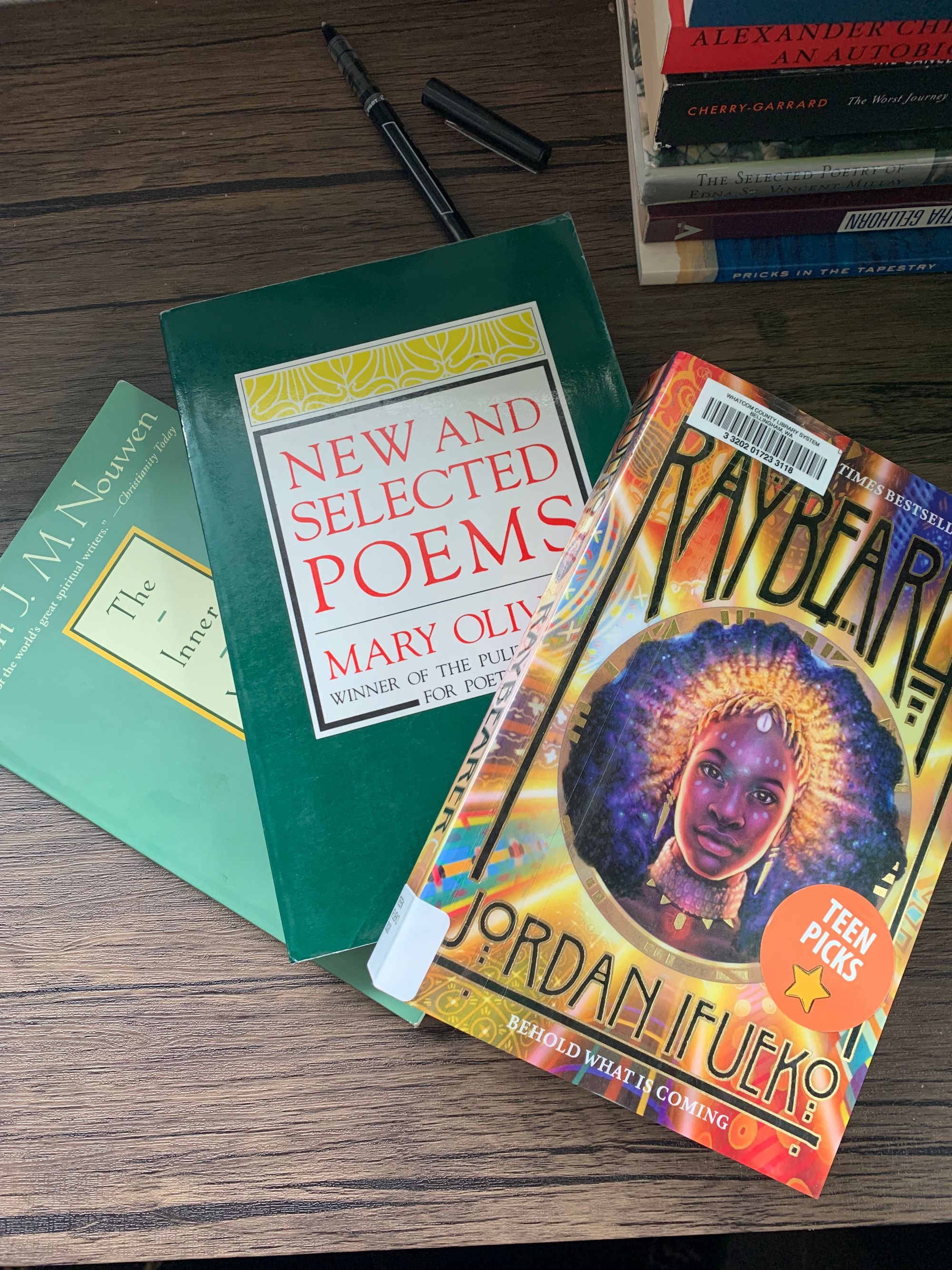 paperback copies of Henri J Nouwen's The Inner Voice of Love, Mary Oliver's New & Selected Poems, Jordan Ifueko's Raybearer