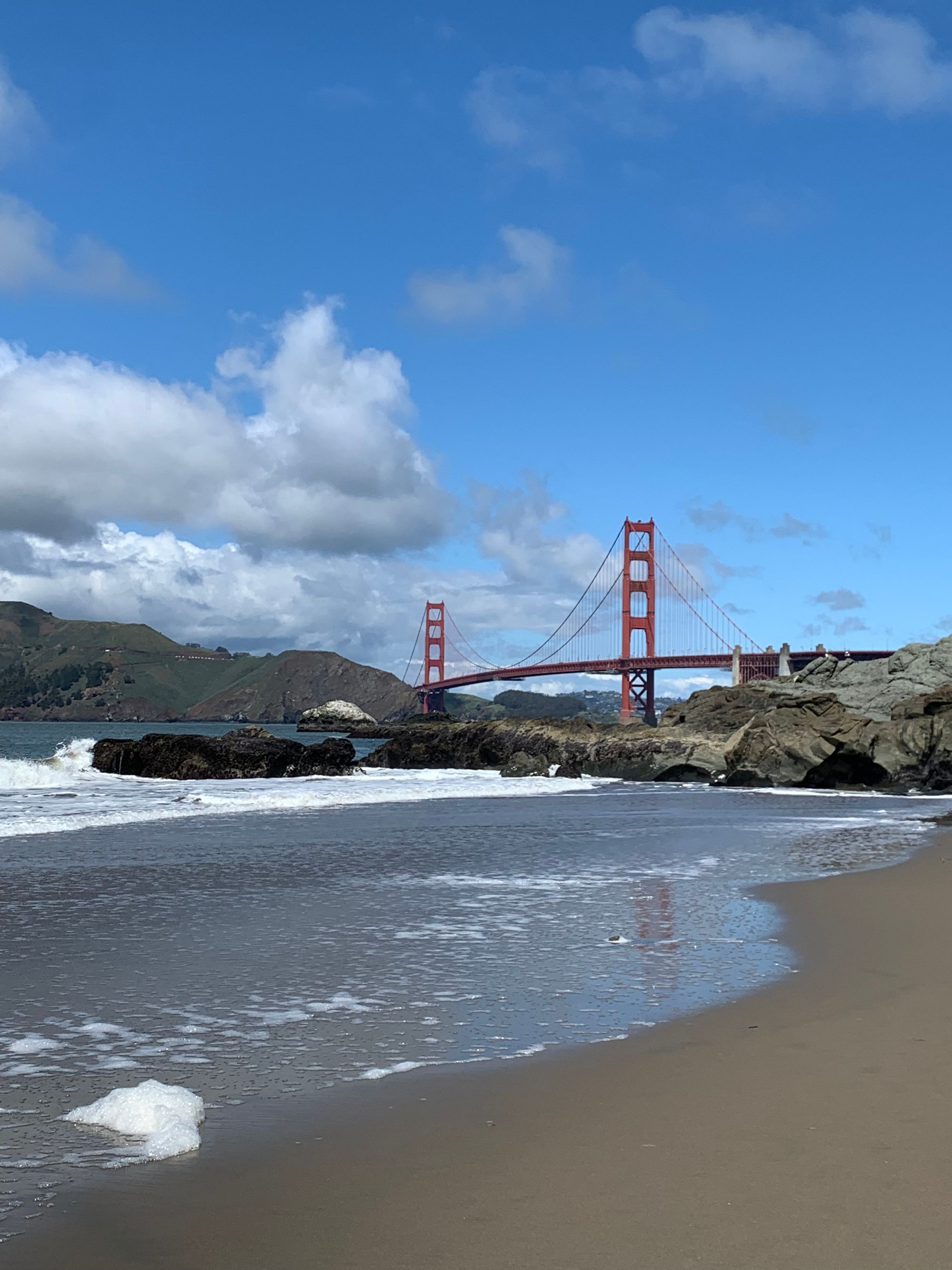 blue skies with clouds, the golden gate bridge, a sandy beach