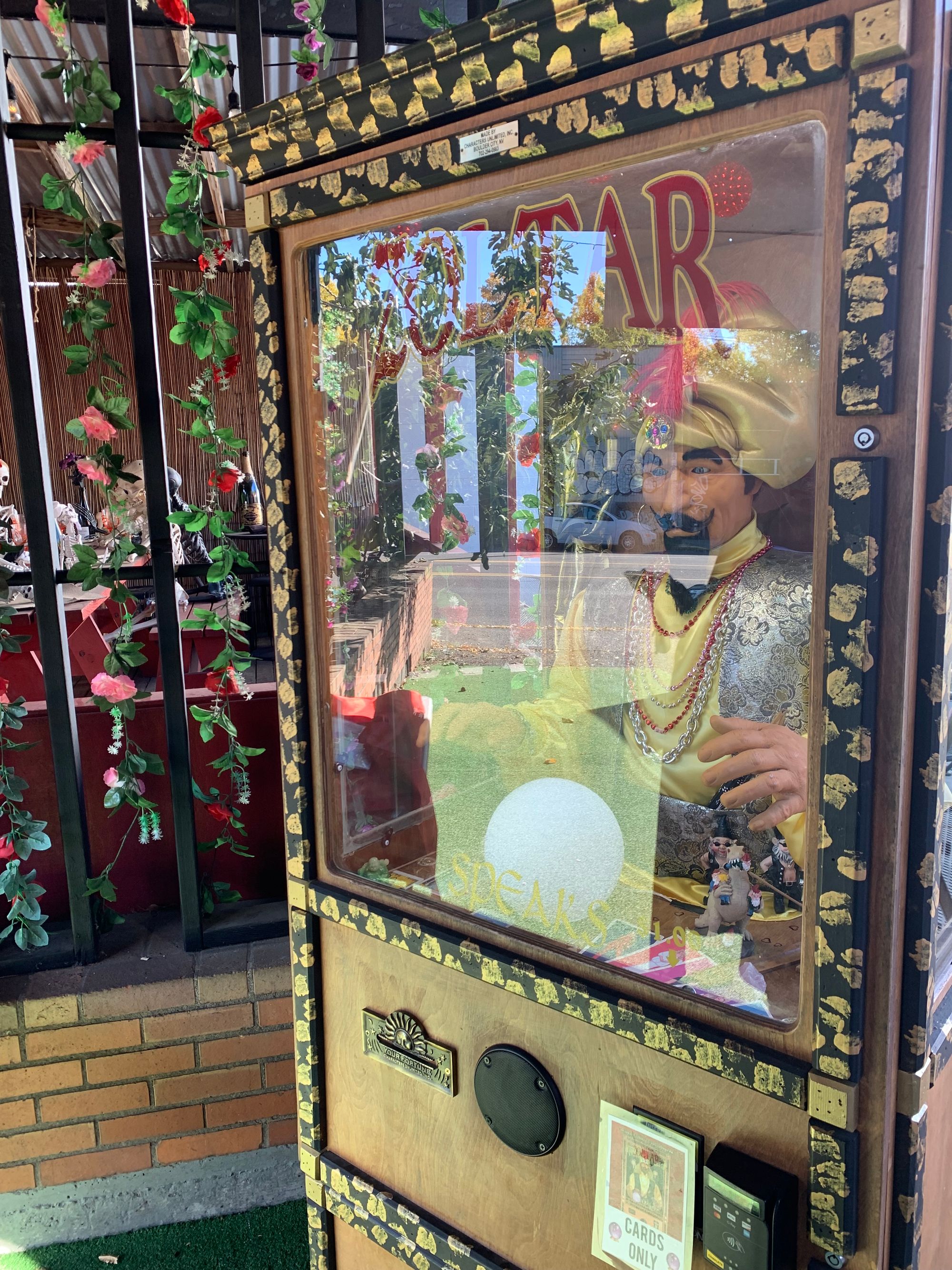 Zoltar Fortune Telling machine with black metal bars & skeletons in the background